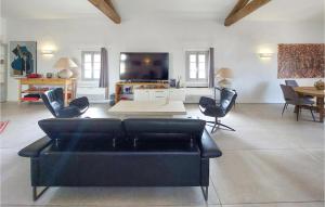 ein Wohnzimmer mit einem schwarzen Sofa und Stühlen in der Unterkunft 3 Bedroom Stunning Home In Murviel Les Montpellie in Murviel-lès-Montpellier