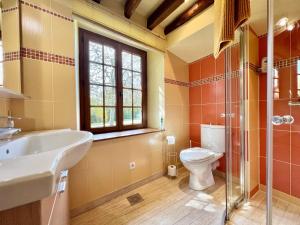 een badkamer met een wastafel, een toilet en een raam bij Le studio Au Bon Maréchal in Giverny
