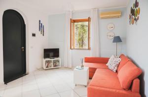 拉維羅的住宿－Casa Ravello，客厅配有橙色沙发和电视