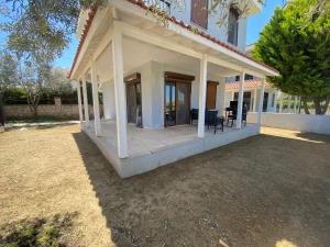 una casa con un portico con sedie sopra di Dublex villa a Çeşme