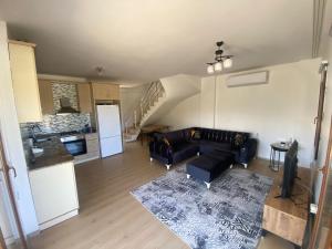 a living room with a couch and a kitchen at Dublex villa in Cesme