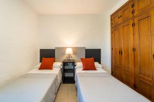 2 camas con almohadas de color naranja en una habitación en Apartamento Jibazahora P6 - Primera Planta, en Zahora