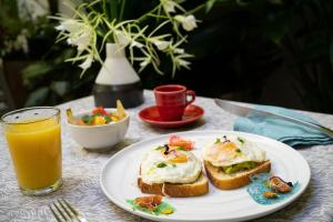 a plate of eggs and toast with a glass of orange juice at Casa Sol Bed and Breakfast in San Juan