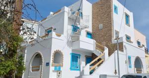 a white building with blue doors and windows at EVI Studios & Apartments in Naxos Chora