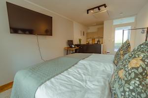 a bedroom with a bed with a flat screen tv on the wall at Studio Apartment mit Parkplatz in Oberesslingen