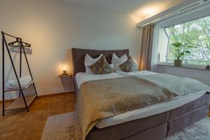 a bedroom with a large bed with a large window at Studio Apartment mit Parkplatz in Oberesslingen