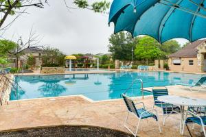 uma piscina com mesa e cadeiras e um guarda-sol em San Antonio Vacation Rental with Patio Near SeaWorld em San Antonio