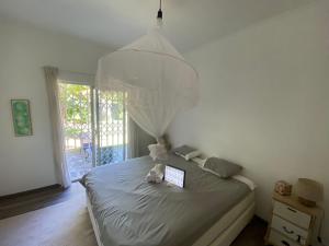 ein Schlafzimmer mit einem Bett und einem Laptop darauf in der Unterkunft Coquette villa privée au bord de l'océan in Pointe aux Cannoniers