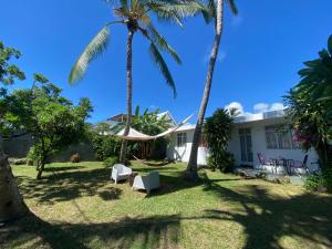 a view of the backyard of a house with palm trees at Coquette villa privée au bord de l'océan in Pointe aux Cannoniers