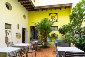 a restaurant with tables and chairs and a yellow wall at Casa Sol Bed and Breakfast in San Juan
