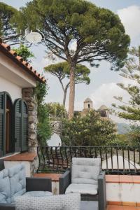 um pátio com duas cadeiras e uma árvore em Casa Ravello em Ravello