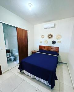 sypialnia z niebieskim łóżkiem i łazienką w obiekcie Pousada da Praia w mieście Paraty