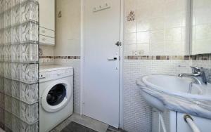 a bathroom with a washing machine and a sink at Casas Blanca 34 piscina Playa privada wifi in Tossa de Mar