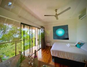 um quarto com uma cama e uma grande janela em Organica Yoga Shelter em Paquera