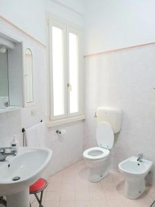 ein weißes Bad mit einem WC und einem Waschbecken in der Unterkunft Amico Del Sole in Rom