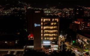 um edifício alto com um cartaz à noite em 1616 Hotel Medellin em Medellín