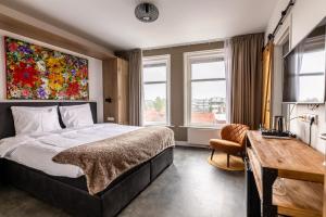 a bedroom with a bed and a desk and windows at Hotel Inn Naeldwyk in Naaldwijk