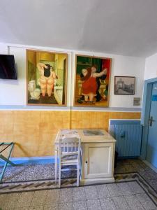una habitación con pinturas en la pared y una mesa en B&B Tony and Judy en Orbetello