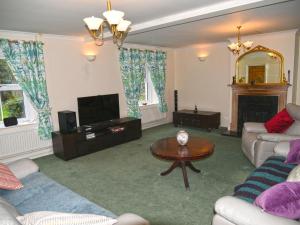sala de estar con sofá y TV en Heathfield, en Taunton