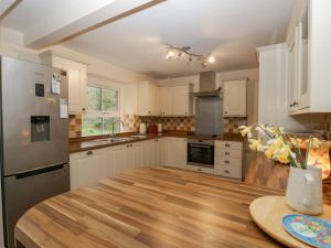 een keuken met witte kasten en een houten tafel bij Heathfield in Taunton