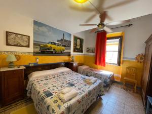 1 dormitorio con 2 camas y un coche amarillo en la pared en B&B Tony and Judy en Orbetello
