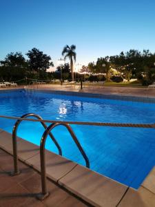 a large swimming pool with blue water at Azienda Agrituristica Baglio Carta in Balestrate