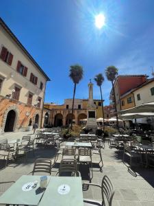 a courtyard with tables and chairs and a clock tower at Pensione Tony and Judy in Orbetello