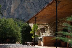 a stone house with a mountain in the background at Torre de Arriba Casa Rural in Benimantell