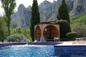 a house with a swimming pool and a gazebo at Torre de Arriba Casa Rural in Benimantell