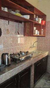 a kitchen counter with a stove and a sink at Résidence H in Yaoundé