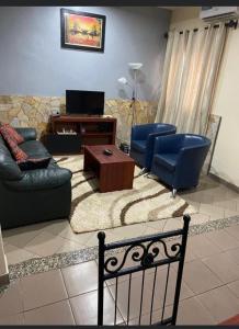 sala de estar con sofá, sillas y mesa en Résidence H en Yaundé