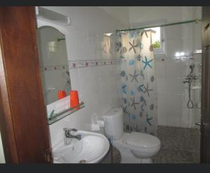 a bathroom with a sink and a toilet and a shower at Résidence H in Yaoundé