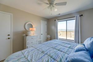 a bedroom with a blue bed and a window at Atlantic Beach Home By Fort Macon State Park in Atlantic Beach