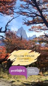 een bord met uitzicht op een geel huis met bomen bij Yellow House Cottage in El Chalten