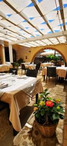 un ristorante con tavoli e sedie con fiori di Azienda Agrituristica Baglio Carta a Balestrate