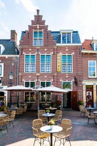 a brick building with tables and chairs in front of it at Inn Naeldwyk in Naaldwijk