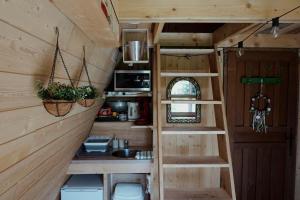 a kitchen in a tiny house with a staircase at Le Chalet Tipi avec jacuzzi et jardin in Troyes