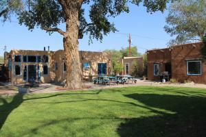 a building with a tree and a picnic table at Casa Mijas - Main Historic House in Albuquerque