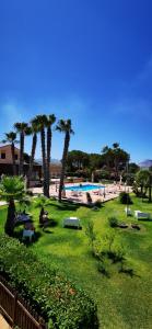 a park with palm trees and a swimming pool at Azienda Agrituristica Baglio Carta in Balestrate