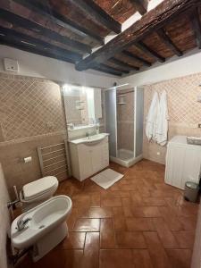 La salle de bains est pourvue de 2 toilettes, d'un lavabo et d'une douche. dans l'établissement L' Antico Lavatoio, à Pitigliano