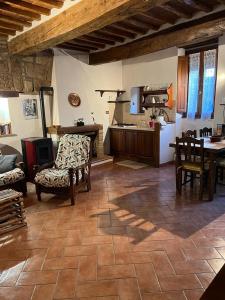 Il comprend une cuisine et un salon avec une table et des chaises. dans l'établissement L' Antico Lavatoio, à Pitigliano