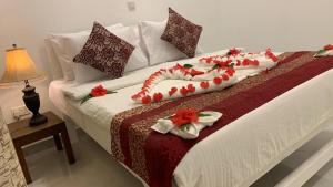- un lit orné de fleurs rouges et blanches dans l'établissement Kiwengwa Minazi Resort, à Kiwengwa