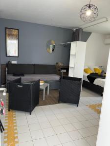 ein Wohnzimmer mit einem Sofa und einem Bett in der Unterkunft Studio Estelle Manganao in Saint-François