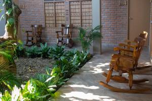 a row of wooden chairs in a courtyard at Hotel Palmas del Río Mompox in Mompos