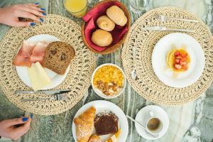 einen Tisch mit Teller mit Speisen und Schüsseln mit Frühstückslebensmitteln in der Unterkunft Unique Hotel in Cesenatico