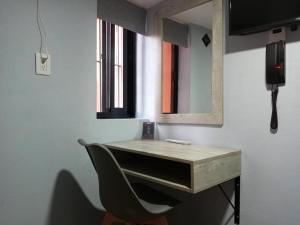 a desk in a room with a chair and a mirror at Hotel Corazón Mexicano in Guanajuato