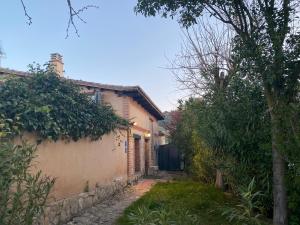 un callejón con una casa y un árbol en Casa rural De Añil - Jardín privado, wifi, netflix y aire acondicionado, en Velliza