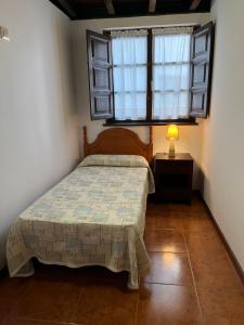 Schlafzimmer mit einem Bett und einem Fenster in der Unterkunft Apartamentos Palombina in Celorio