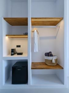 a walk in closet with white walls and a wooden bench at Paros Five Senses in Parikia