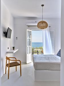 a bedroom with a bed and a view of the ocean at Paros Five Senses in Parikia